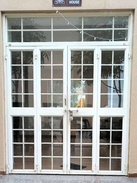 White balcony safety door with an intricate geometric grill design.